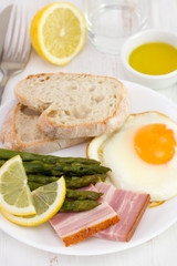 fried egg with bacon, bread and asparagus