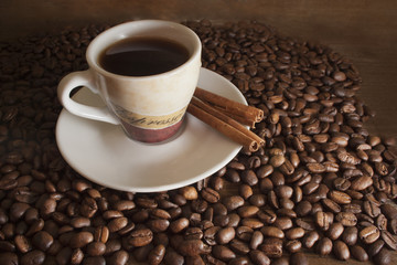 cup of coffee on a background coffee beans and brown wooden boar