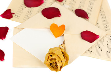 Old envelope with blank paper and dried rose