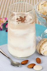 Glass of chocolate-cream cocktail on beige tablecloth close-up