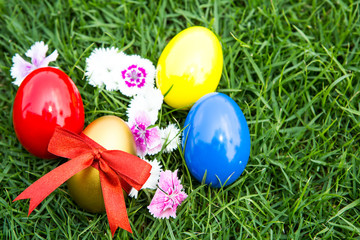 Easter eggs on green grass with flower