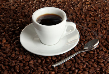 Cup of coffee on coffee beans background