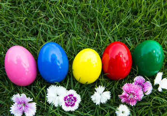Fototapeta na wymiar Easter eggs on green grass with flower