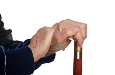 Elderly hands resting on stick