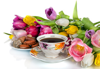 Bouquet of colorful tulips and  tea cup full of tea isolated on