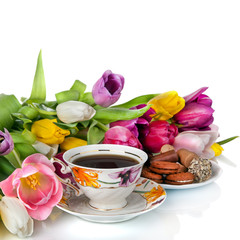 Bouquet of colorful tulips and  tea cup full of tea isolated on