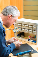 Akustiker arbeitet an einem Hörgerät