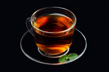 cup of black tea with mint on a black background