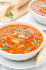 Vegetable soup with white beans in a bowl closeup vertical