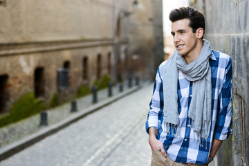 Fototapeta na wymiar Handsome man with modern hairstyle smiling in urban background