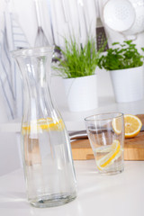 glass and carafe with lemonade on a kitchen counter