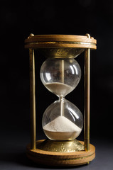 Old hourglass on black background