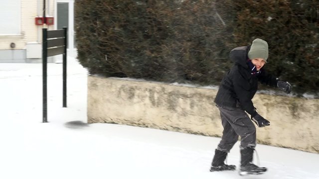 gar&ccedil;on jouant &agrave; dans la neige