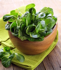 Fresh green salad valerian in a wooden bowl