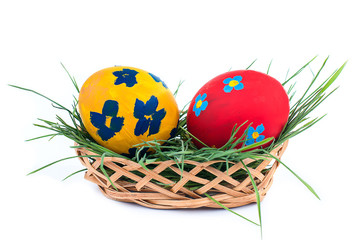 two Easter eggs in a basket on a white background