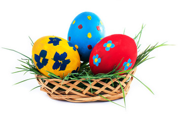 Three Easter eggs in a basket on a white background