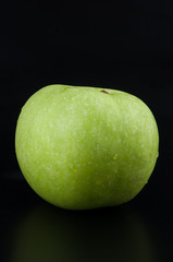 Fresh green apple on black background