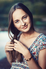 Naklejka premium Beautiful young blond woman outdoors portrait near the lake