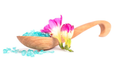 Spa salt in wooden spoon with beautiful pink Freesia flower. 