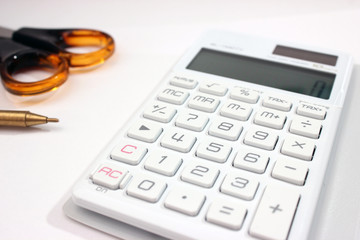 Office desk calculator with scrissors aside of pen