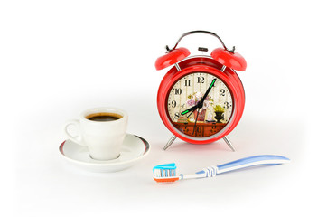 Red alarm clock, coffee and a toothbrush