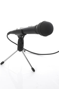 A microphone with a cord in a holder