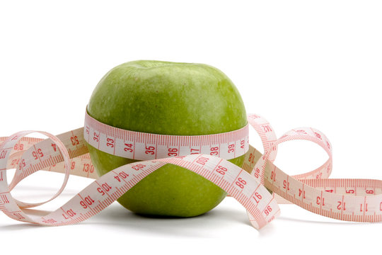 A green apple and a measuring tape