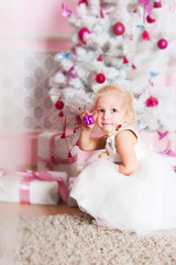 The girl at the Christmas fir-tree with gifts
