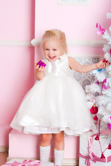 The girl at the Christmas fir-tree with gifts