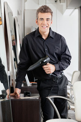 Happy Male Hairdresser With Hairdryer