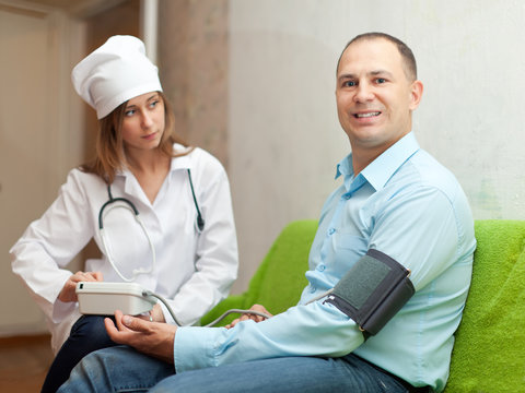 Doctor measuring blood pressure of patient