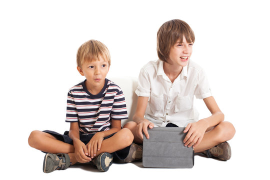 Два мальчика с планшетом сидят на полу