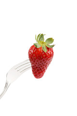 Strawberry on a fork isolated on white background.