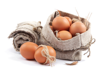 Brown eggs in canvas sack isolated on a white background.