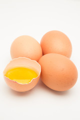 Obraz premium Three eggs with raw yolk in half a shell