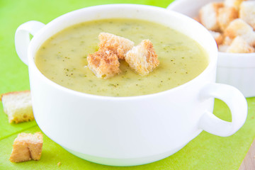 Zucchini cream soup with croutons in white cup