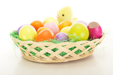 Obraz na płótnie Canvas Easter eggs in a basket with chick