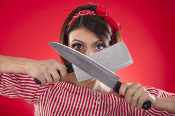 retro girl looking between two kitchen knives