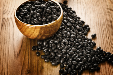 Black beans on wooden background