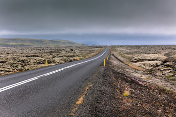 Highway through Iceland landscape at overcast day
