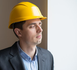 Worker in a helmet on a background window