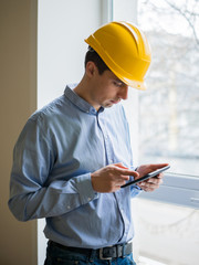 The builder in a helmet with a tablet