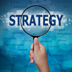 STRATEGY in Magnifying glass on blue background