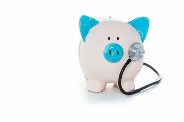 Stethoscope listening to piggy bank