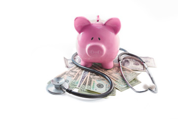 Piggy bank and stethoscope resting on pile of dollars