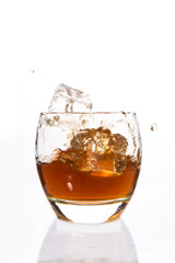 Ice cubes falling in a tumbler of whiskey