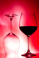 two glasses of wine on red