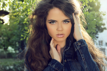 Naklejka premium Young woman outdoors portrait. Soft sunny colors