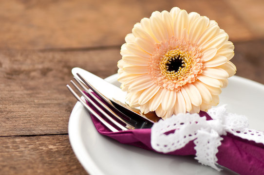 Holzuntergrund mit Besteck und Blume