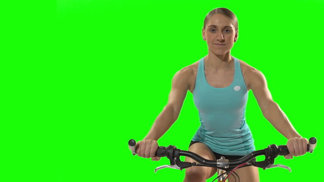 Young woman biking front shot on green screen.